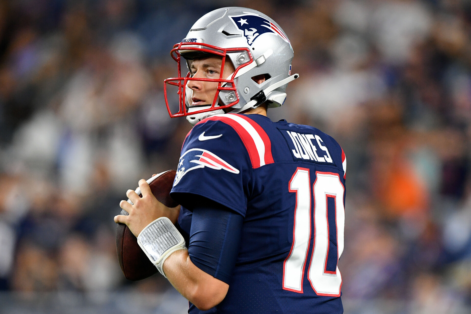New England Patriots quarterback Mac Jones drops back to pass and looks down the field for an open receiver