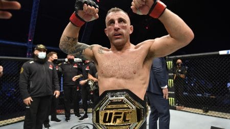 UFC featherweight champion Alexander Volkanovski shows off his title belt.