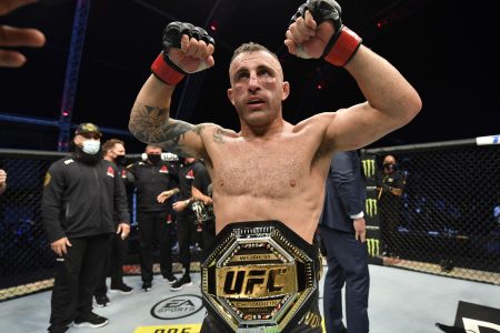 UFC featherweight champion Alexander Volkanovski shows off his title belt.