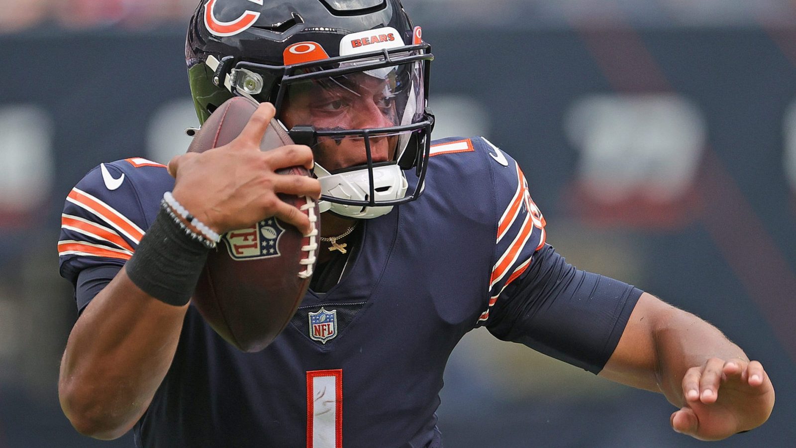 Chicago Bears QB #1 Justin Fields runs the ball in a 2021 home game at Soldier Field in Chicago, IL.