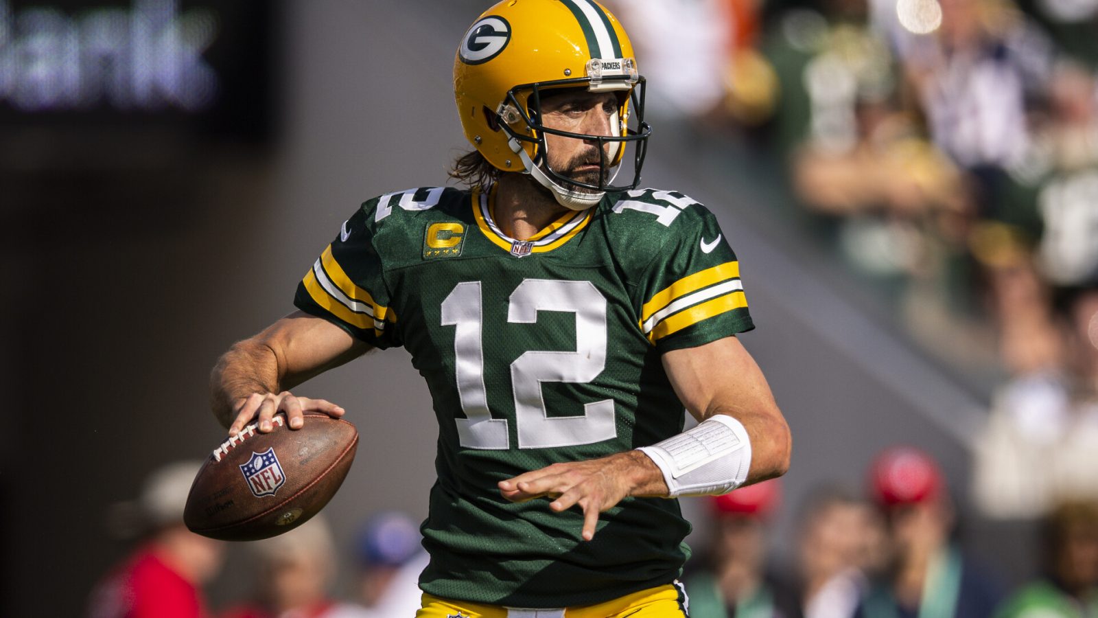 Green Bay quarterback #12 Aaron Rodgers looks downfield in a 2021 home game.