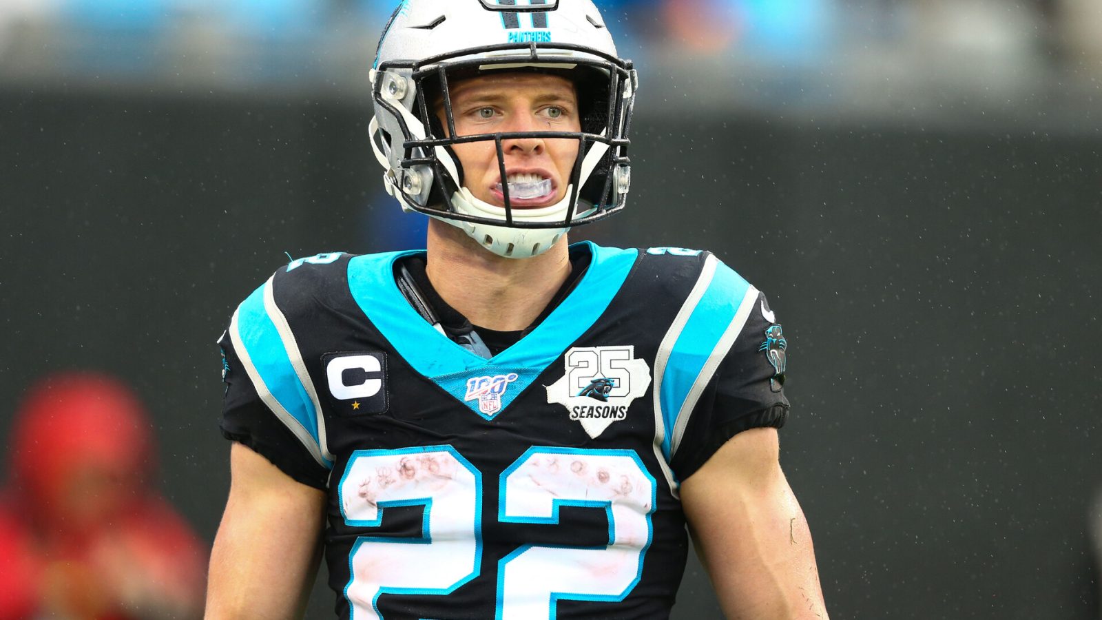Carolina Panthers running back #22 Christian McCaffrey looks on from the sideline in a 2020 home game.