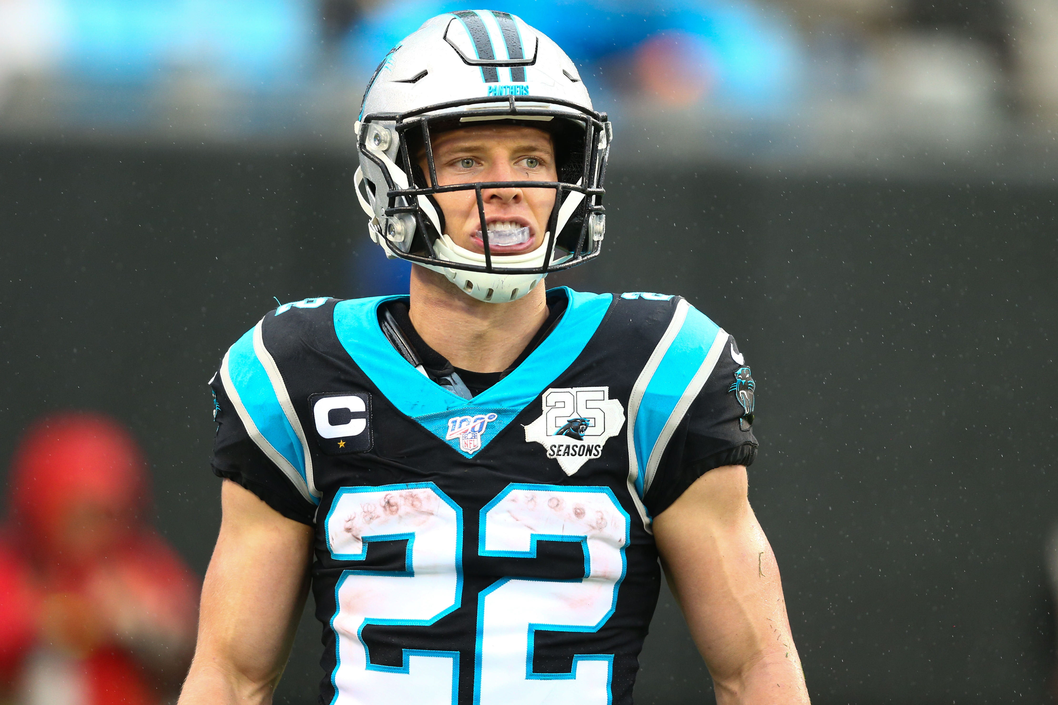 Carolina Panthers running back #22 Christian McCaffrey looks on from the sideline in a 2020 home game.