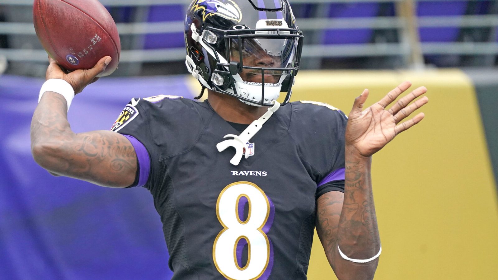 Baltimore Ravens quarterback Lamar Jackson cocks his arm to throw a pass in a game