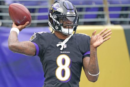 Baltimore Ravens quarterback Lamar Jackson cocks his arm to throw a pass in a game