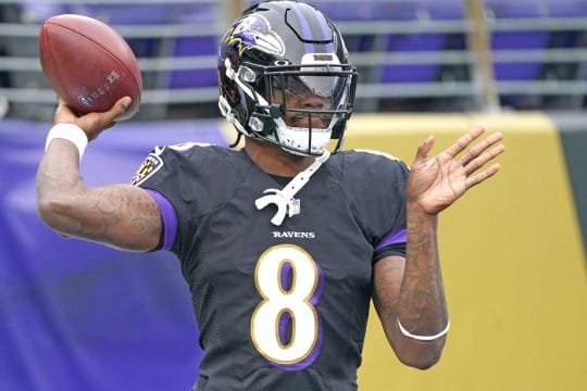 Baltimore Ravens quarterback Lamar Jackson cocks his arm to throw a pass in a game