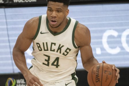 Milwaukee Bucks forward #34 Giannis Antetonkoumpo brings the ball up the court in a 2020 home game.