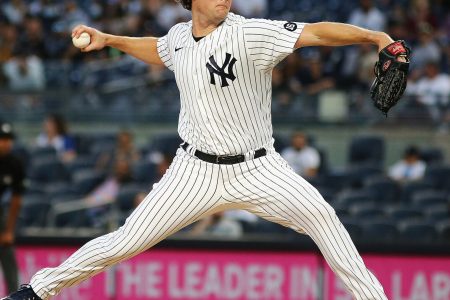 New York Yankees right-handed pitcher Gerrit Cole strides toward the plate while delivering a pitch