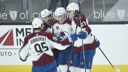 Four Colorado Avalanche players celebrate after their team scored a goal