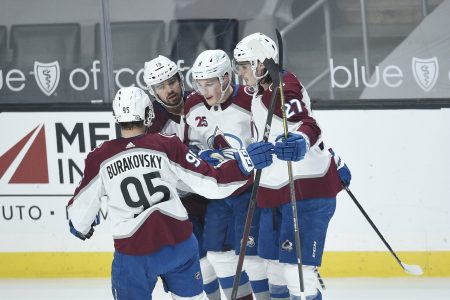 Four Colorado Avalanche players celebrate after their team scored a goal