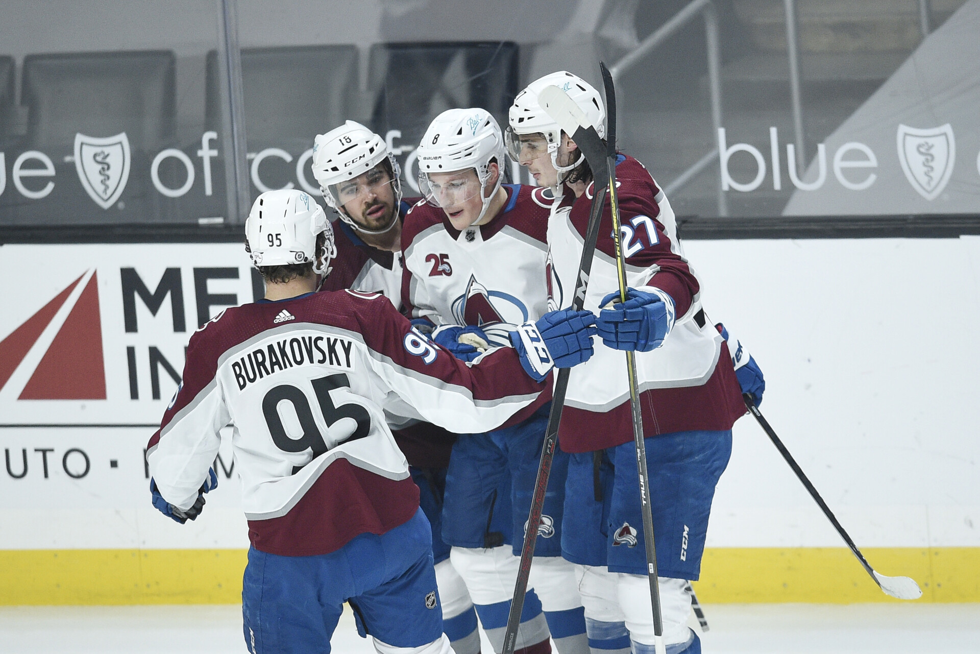 Four Colorado Avalanche players celebrate after their team scored a goal