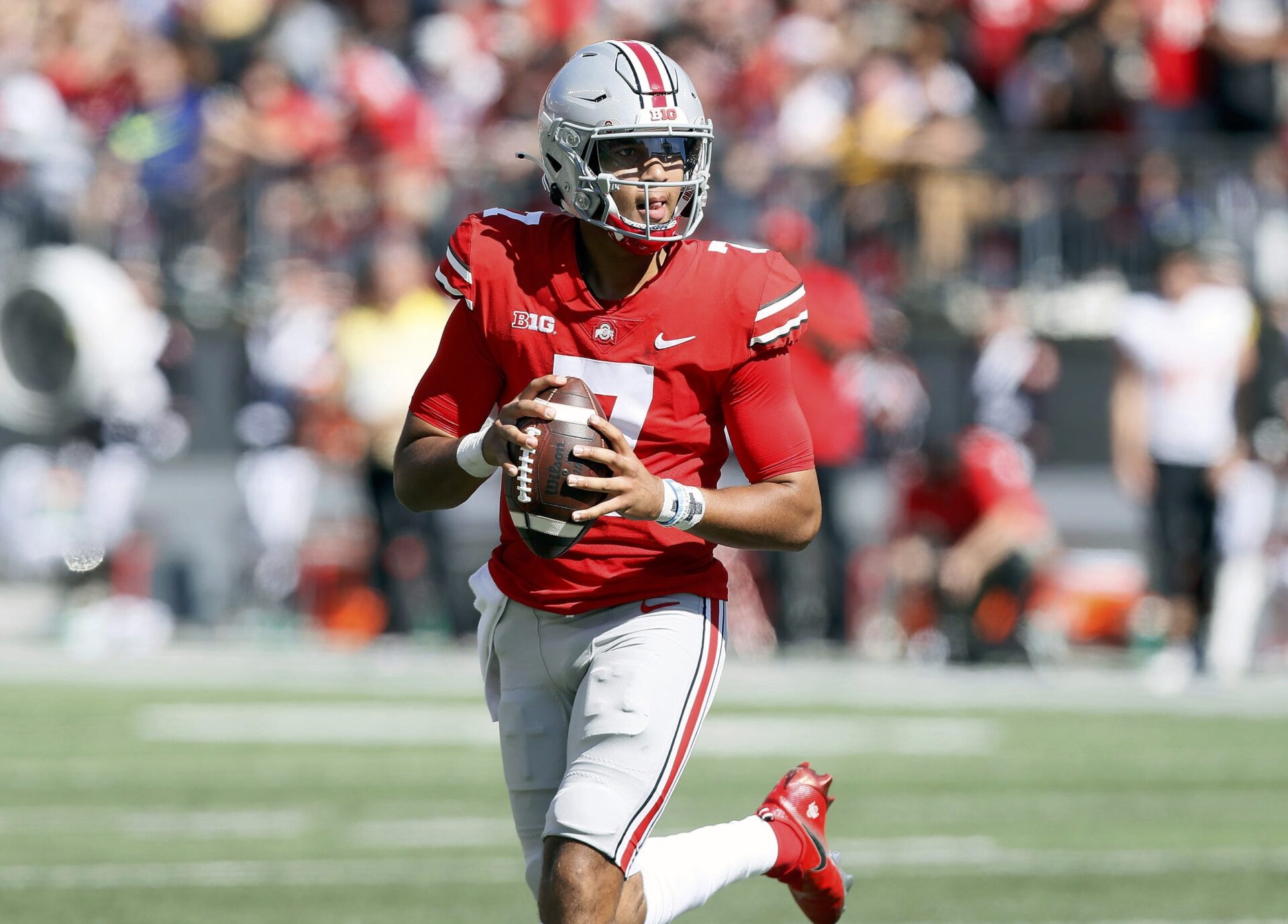 Ohio State quarterback C.J. Stroud holds the football at his waist as he rolls out to pass