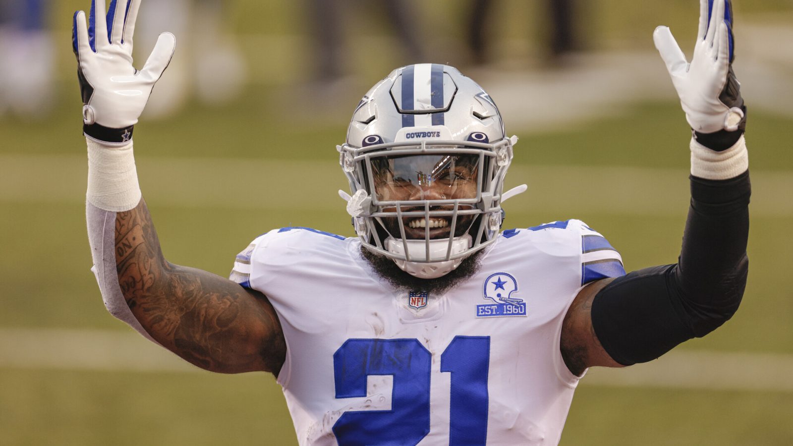 Dallas Cowboys running back Ezekiel Elliott raises his arms to signal a touchdown