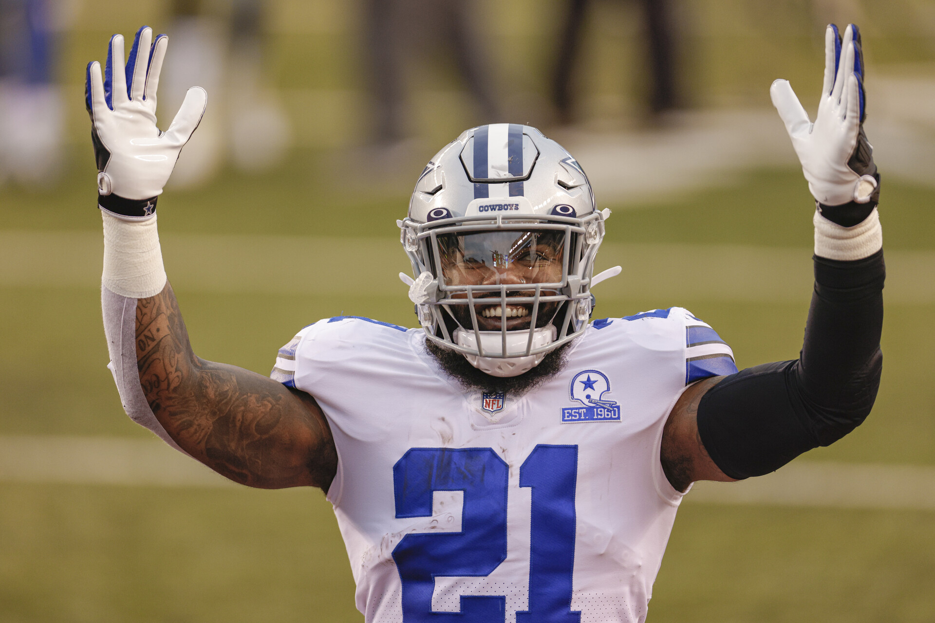 Dallas Cowboys running back Ezekiel Elliott raises his arms to signal a touchdown