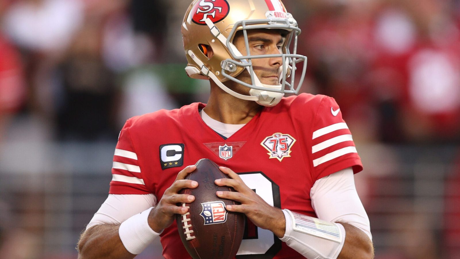 San Francisco quarterback #10 Jimmy Garoppolo looks downfield for a receiver in a 2021 home game.