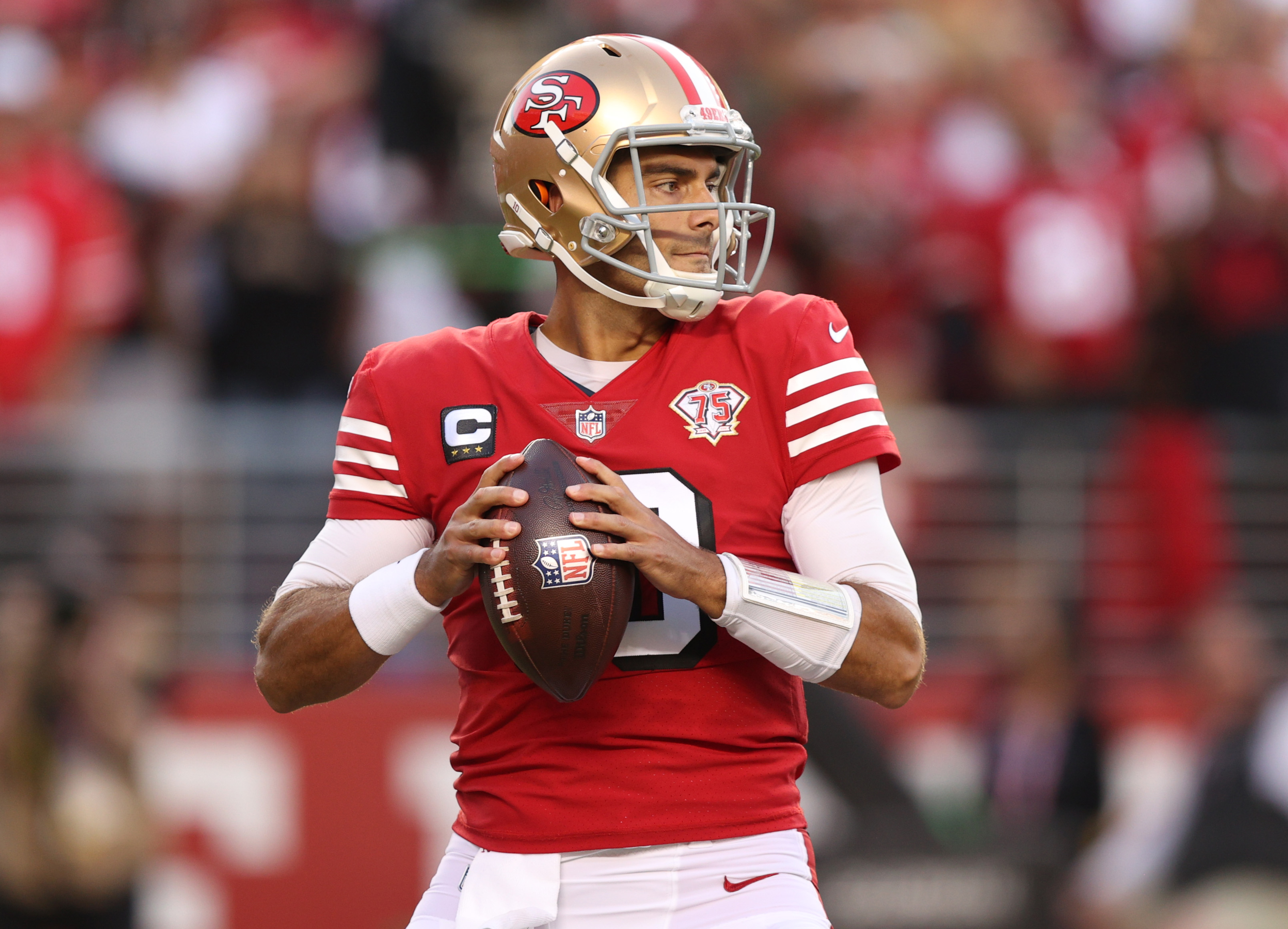 San Francisco quarterback #10 Jimmy Garoppolo looks downfield for a receiver in a 2021 home game.