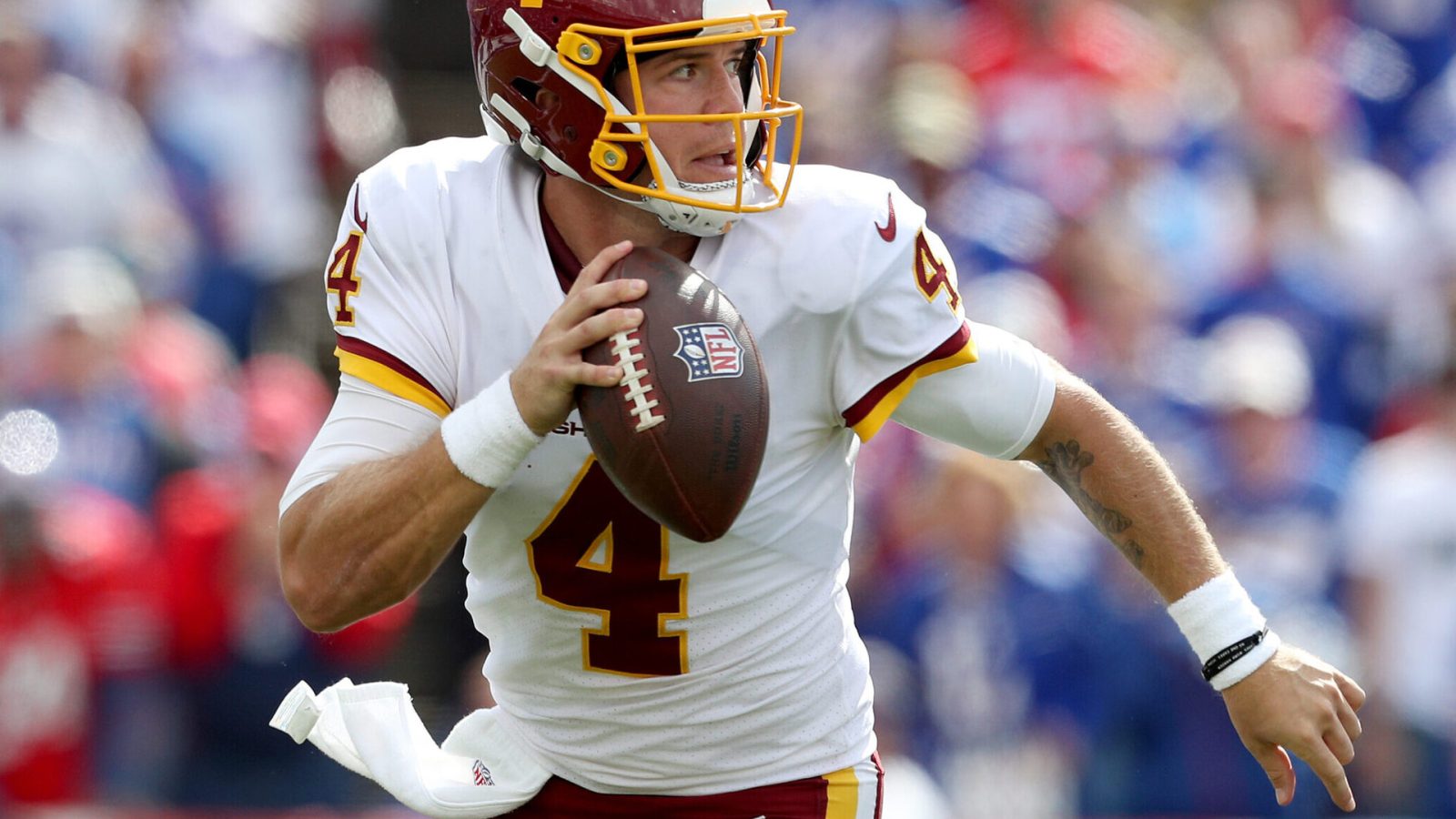Washington Football Team quarterback #4 Taylor Heinicke scrambles out of the pocket against the Bills.
