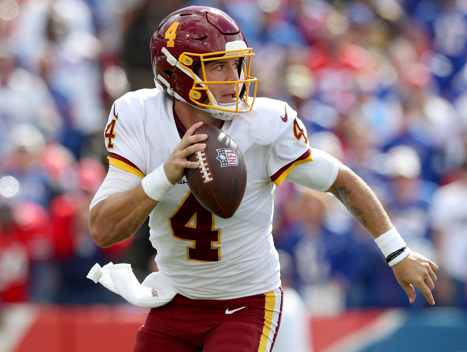 Washington Football Team quarterback #4 Taylor Heinicke scrambles out of the pocket against the Bills.
