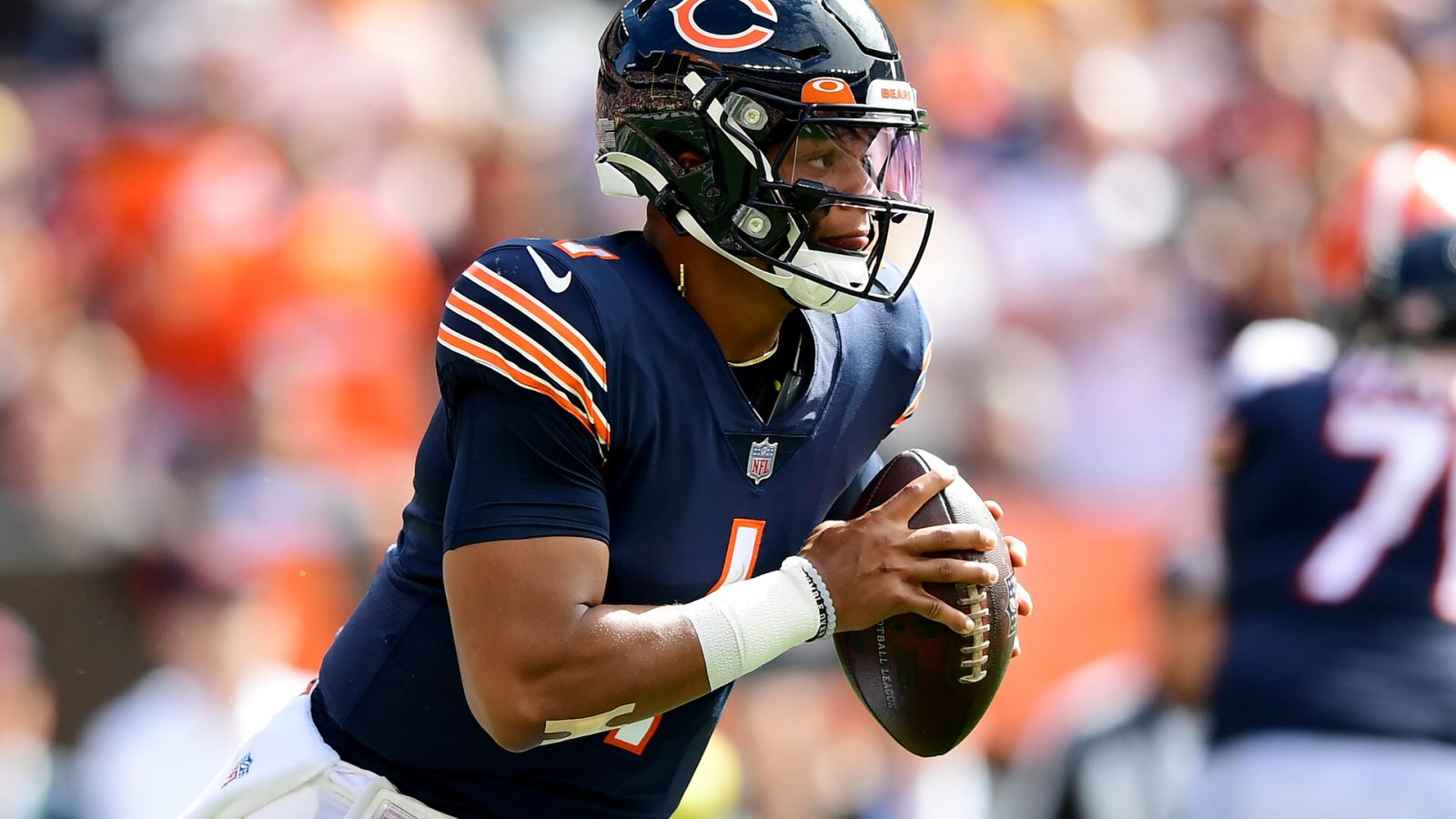 Chicago Bears quarterback #1 Justin Fields looks for a receiver in a 2021 home game.