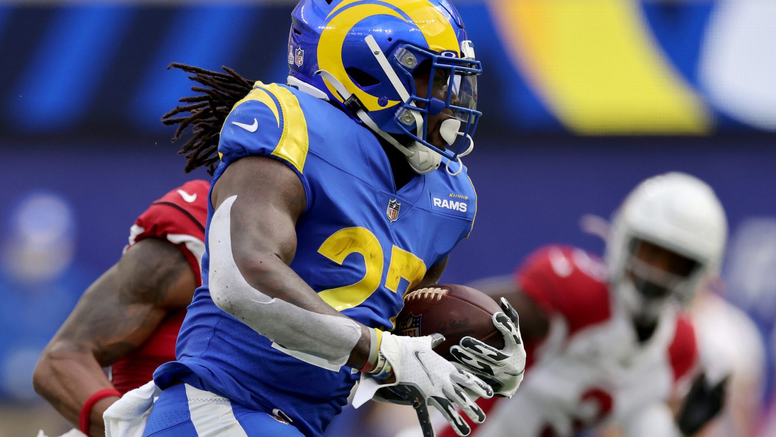 Los Angeles Rams running back #27 Darrell Henderson tries to find running room in a 2021 home game against the Arizona Cardinals.