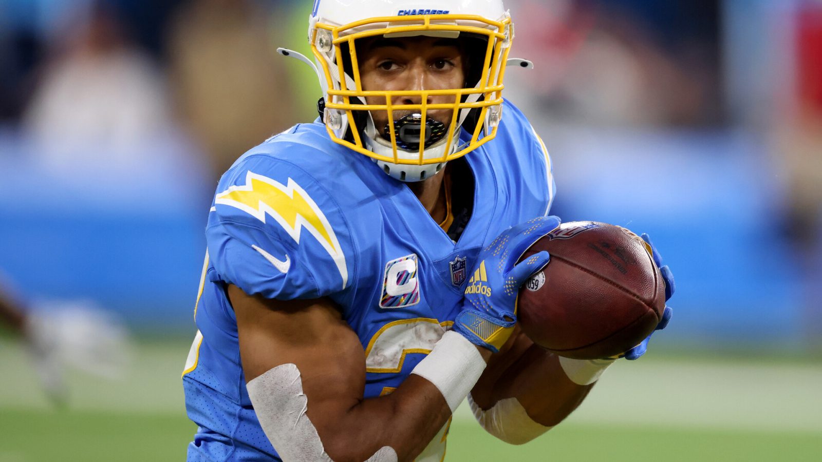 Los Angeles Chargers running back #30 Austin Ekeler looks upfield for running room in a 2021 home game.