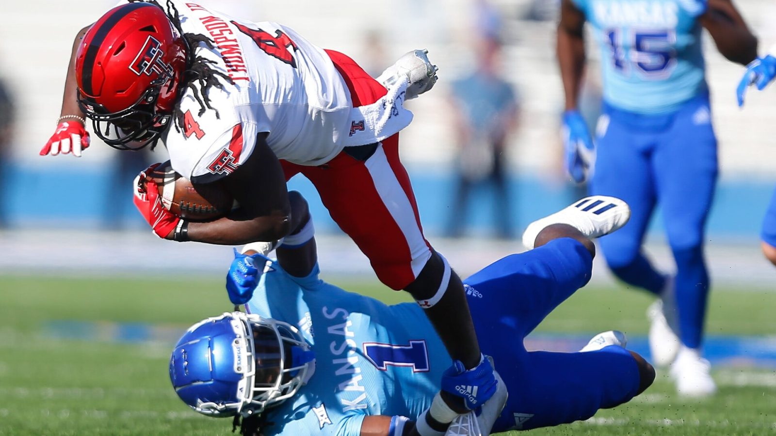 Kansas safety Kenny Logan Jr. falls to the ground while tackling Texas Tech running back Sarodorick Thompson