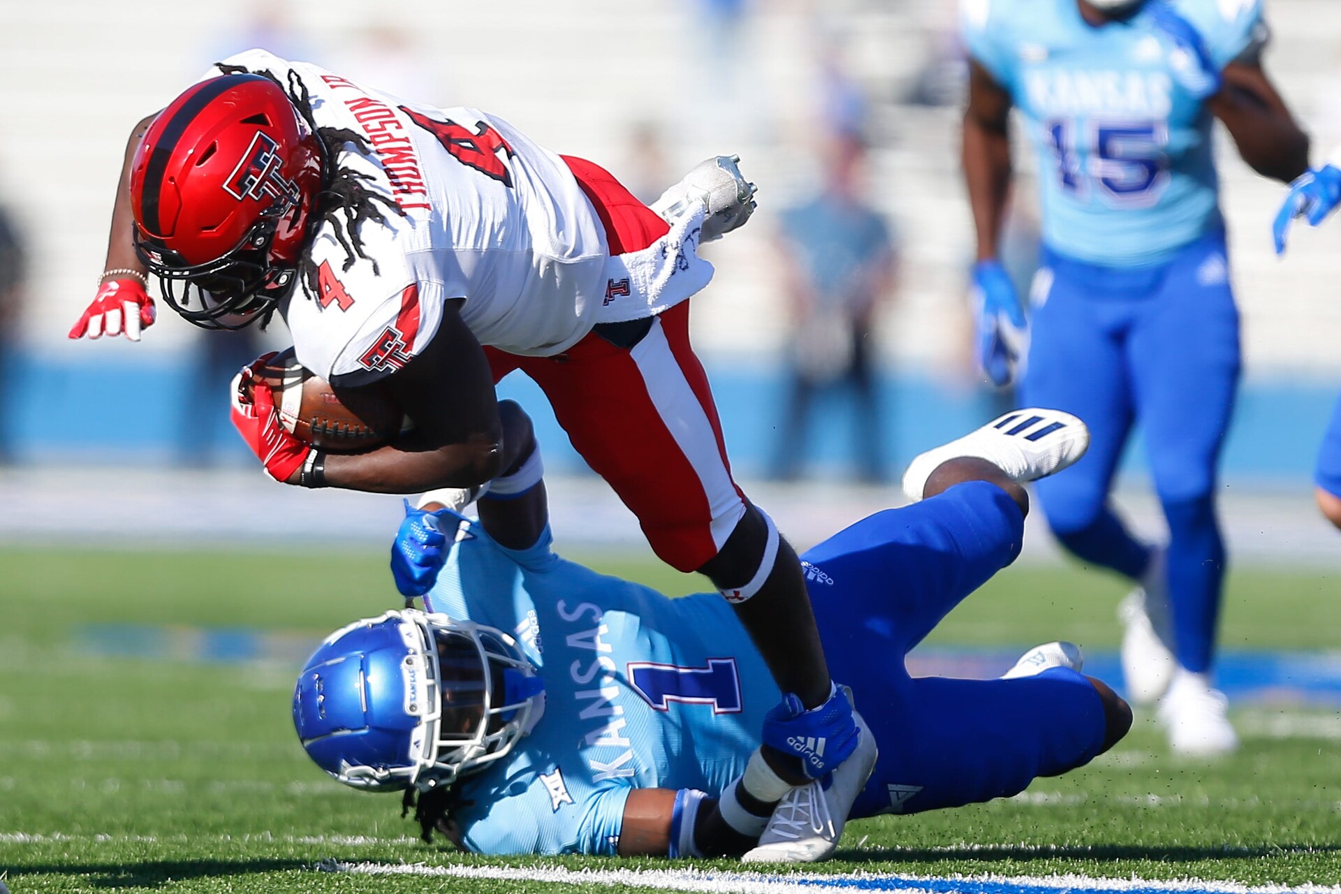 Kansas safety Kenny Logan Jr. falls to the ground while tackling Texas Tech running back Sarodorick Thompson