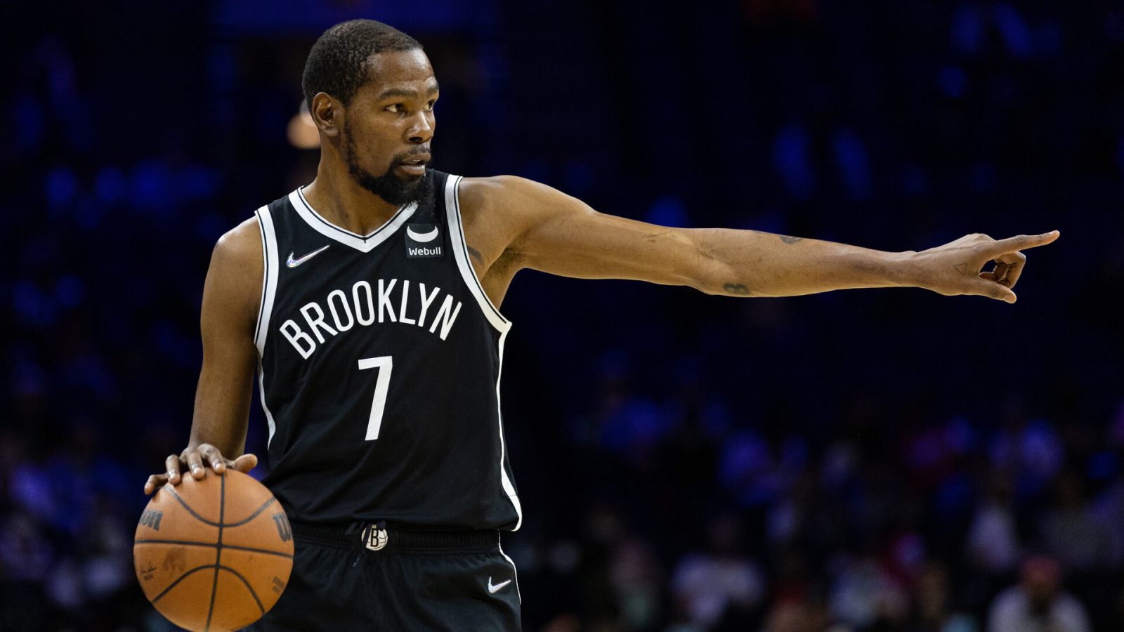 Brooklyn Nets forward Kevin Durant dribbles the ball with his right hand and points with his left