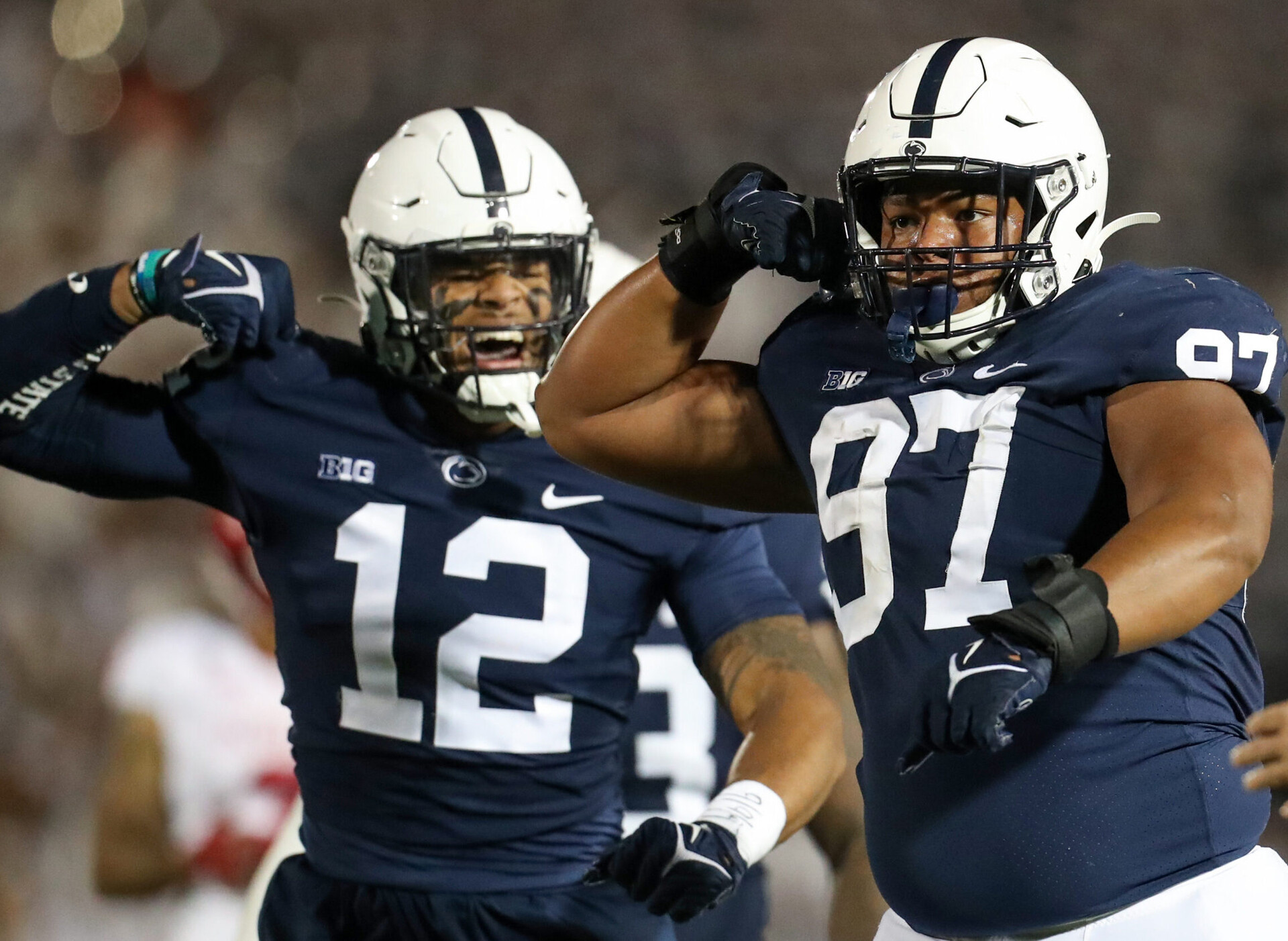 Two unidentified Penn State defensive football players flexing after making a big play