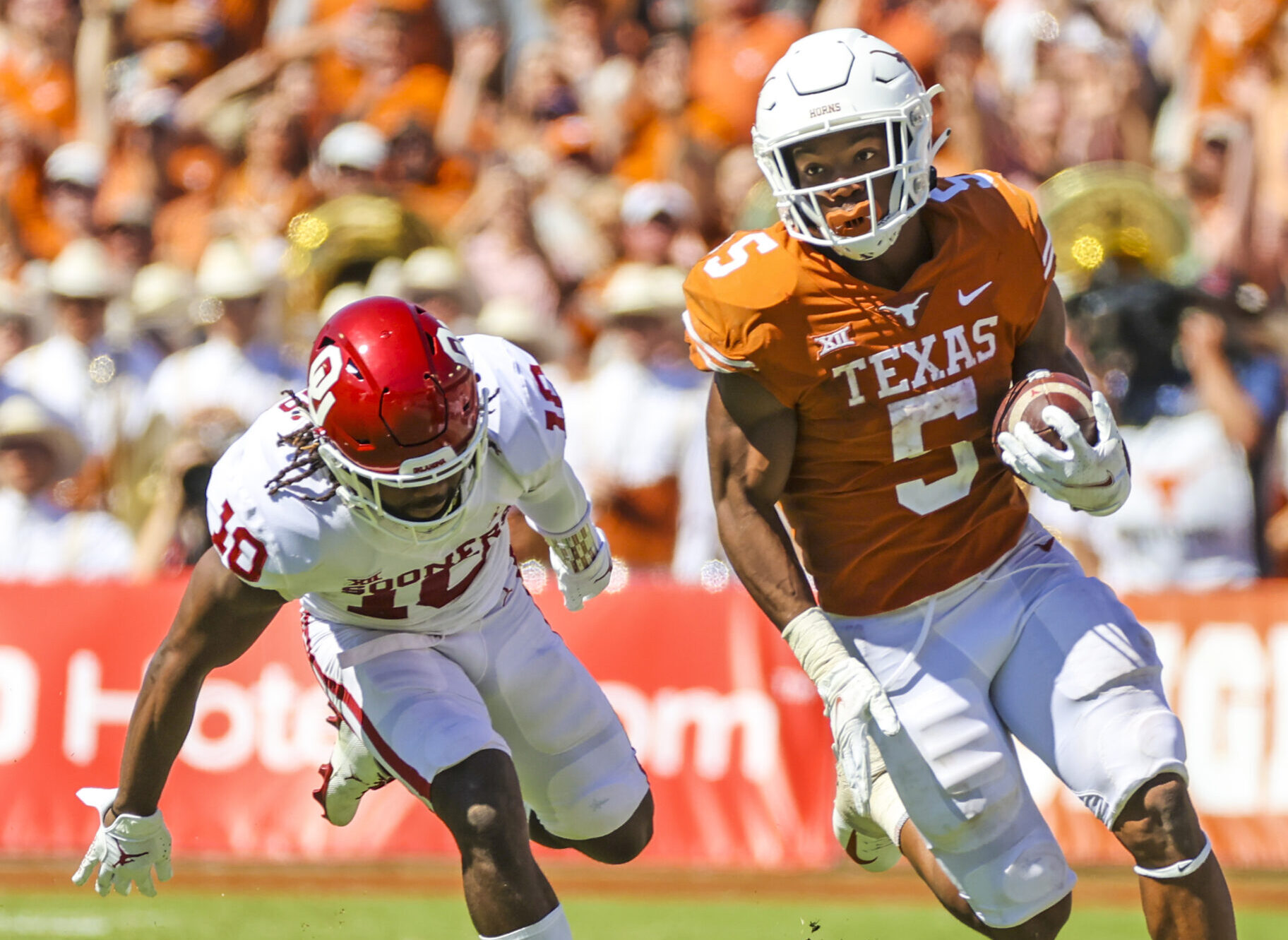 Texas running back Bijan Robinson eludes and Oklahoma tackler on a run down the field