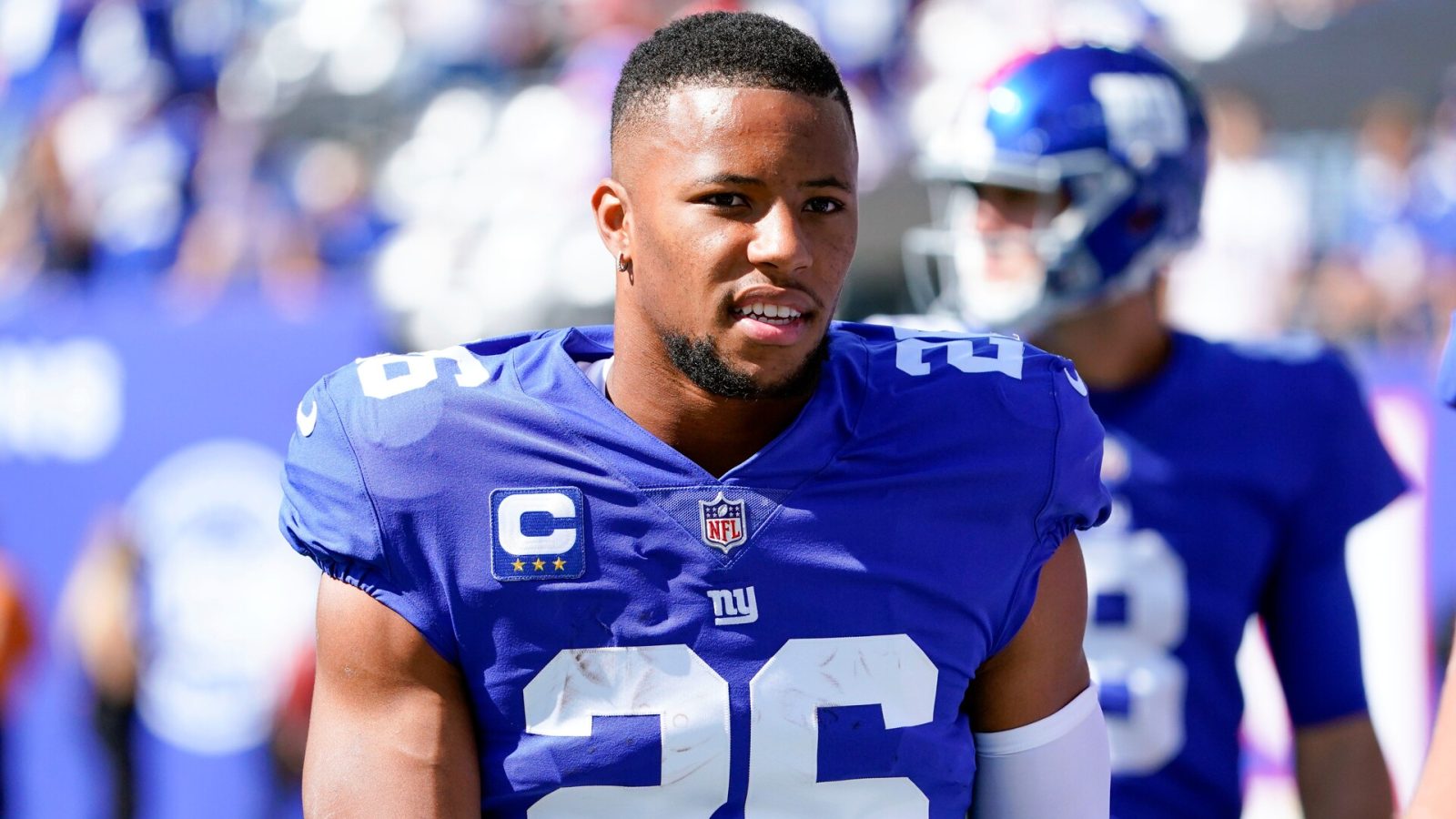 New York Giants running back #26 Saquon Barkley looks on from the sideline in a 2021 home game.