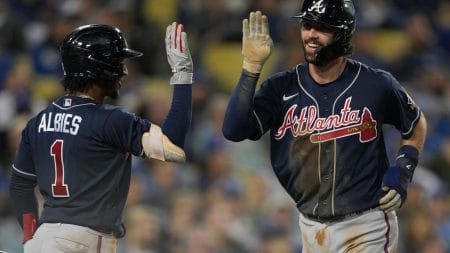 Atlanta Braves shotstop Ozzie Albies (left) greets teammate and shortstop Dansby Swanson with a high-five after Swanson hit a home run