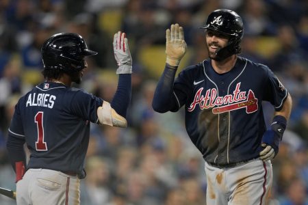 Atlanta Braves shotstop Ozzie Albies (left) greets teammate and shortstop Dansby Swanson with a high-five after Swanson hit a home run