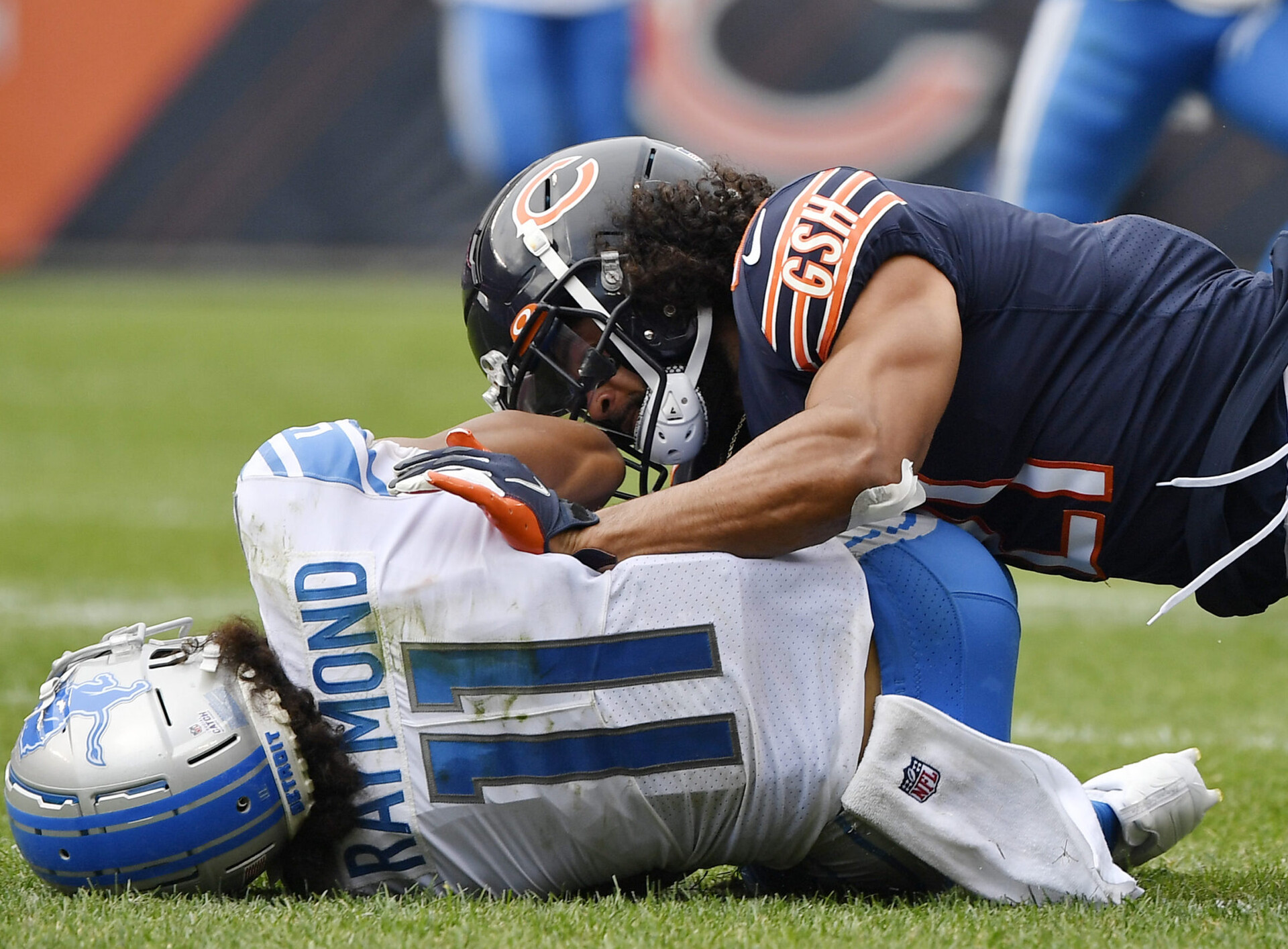 Chicago Bears defensive back Xavier Crawford (right) tackles Detroit Lions wide receiver Kalif Raymond (left)