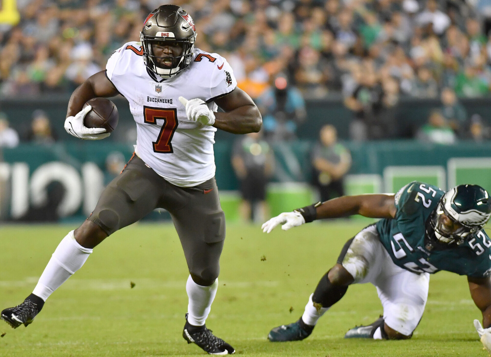 Tampa Bay Buccaneers running back Leonard Fournette (left) runs away from Philadelphia Eagles linebacker Davion Taylor (left)