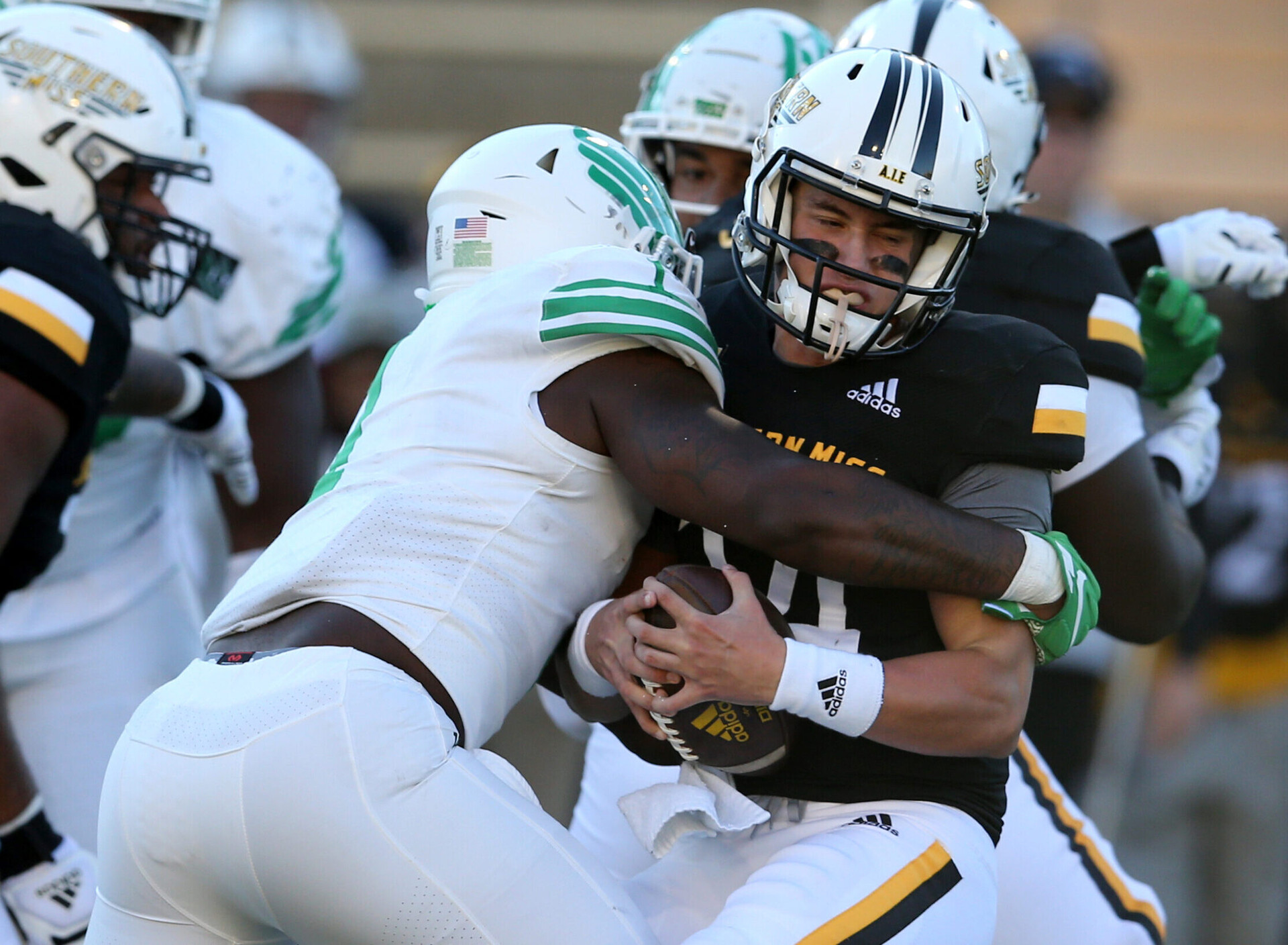 Southern Miss Golden Eagles quarterback Jake Lange (24) is sacked by North Texas Mean Green linebacker KD Davis (1)