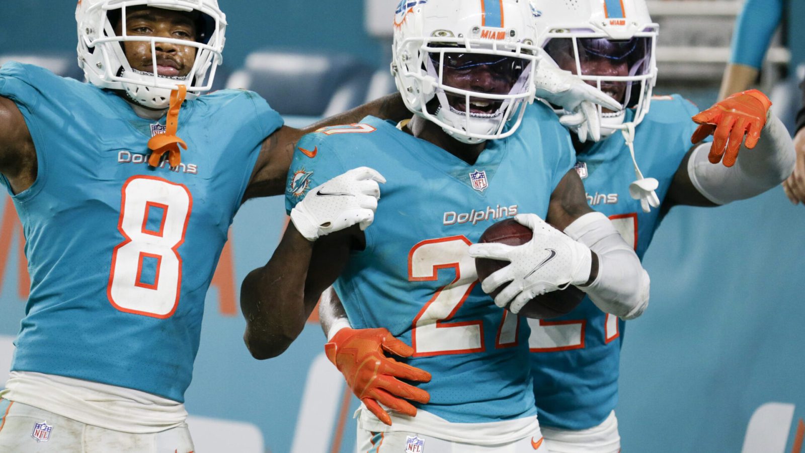 Miami Dolphins cornerback Justin Coleman (center) holds the football and celebrates with teammates after intercepting the football against the Baltimore Ravens