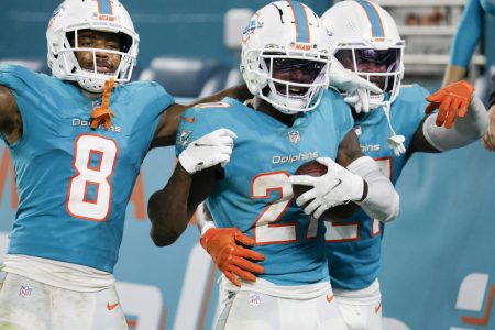 Miami Dolphins cornerback Justin Coleman (center) holds the football and celebrates with teammates after intercepting the football against the Baltimore Ravens