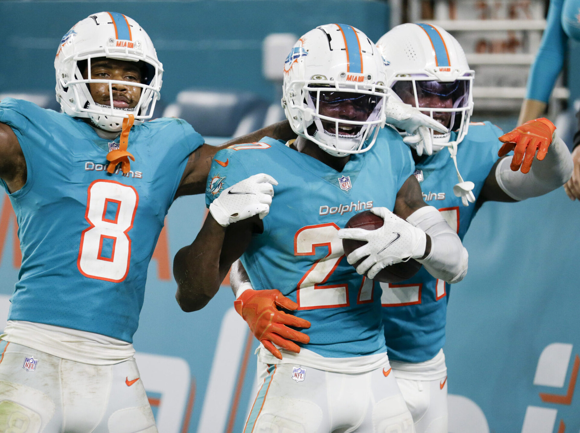 Miami Dolphins cornerback Justin Coleman (center) holds the football and celebrates with teammates after intercepting the football against the Baltimore Ravens