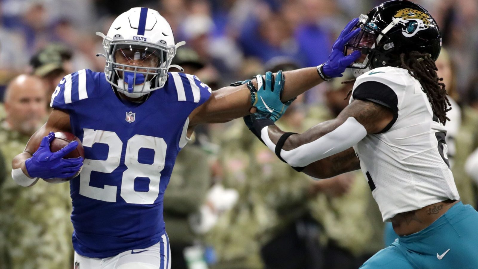 Colts running back Jonathan Taylor still arms Jacksonville Jaguars free safety Rayshawn Jenkins (right)