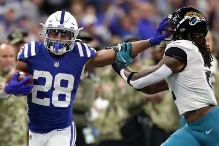Colts running back Jonathan Taylor still arms Jacksonville Jaguars free safety Rayshawn Jenkins (right)