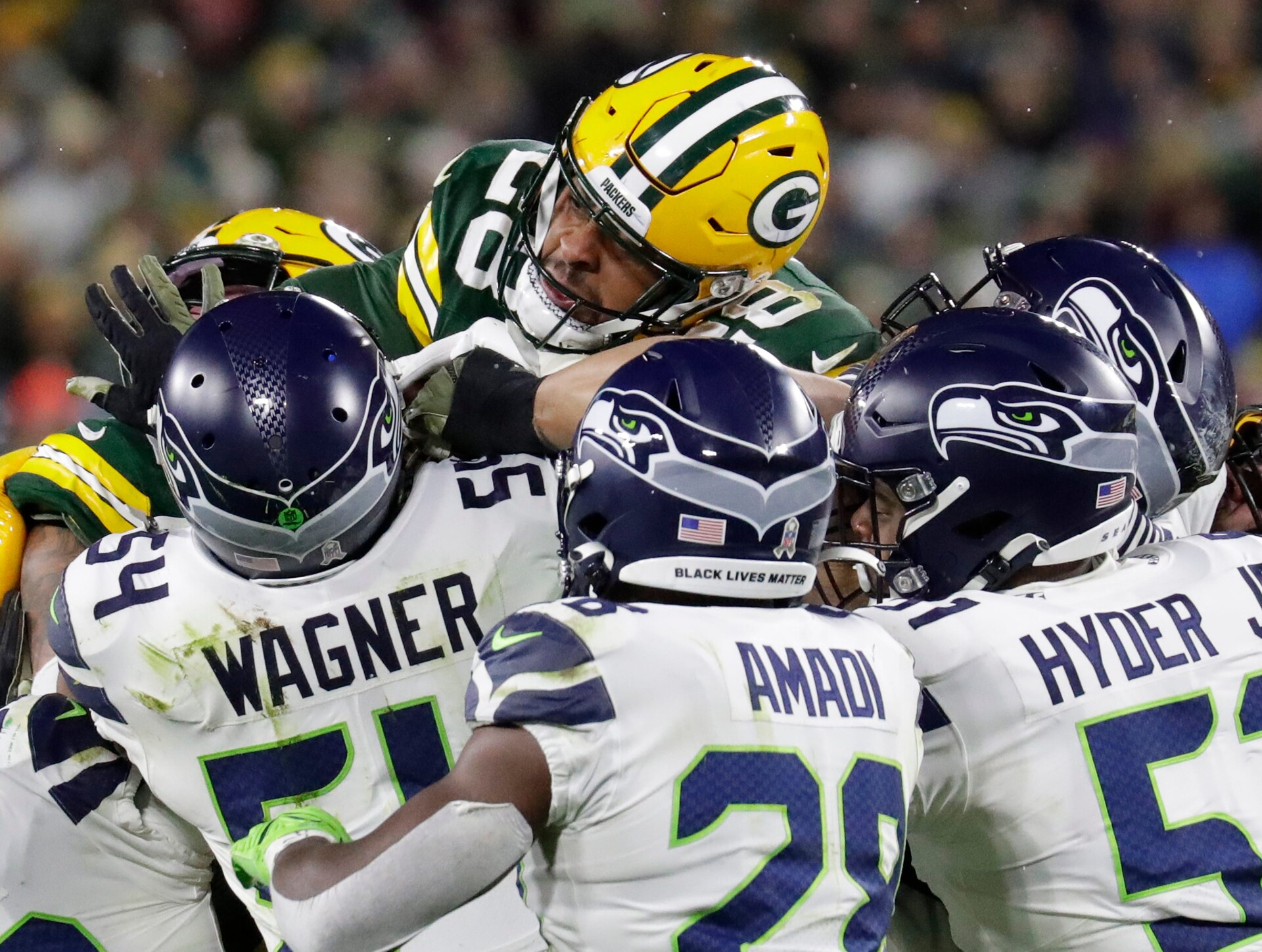 A swarm of Seattle Seahawks defensive players gang tackles Green Bay Packers running back A.J. Dillon