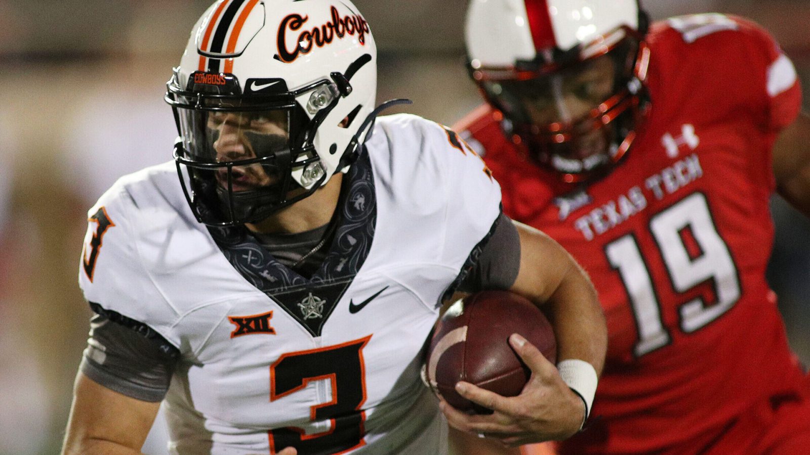 Oklahoma State Cowboys quarterback Spencer Sanders (left) runs the ball against Texas Tech Red Raiders defensive lineman Tyree Wilson (right)