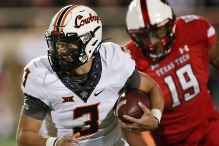 Oklahoma State Cowboys quarterback Spencer Sanders (left) runs the ball against Texas Tech Red Raiders defensive lineman Tyree Wilson (right)