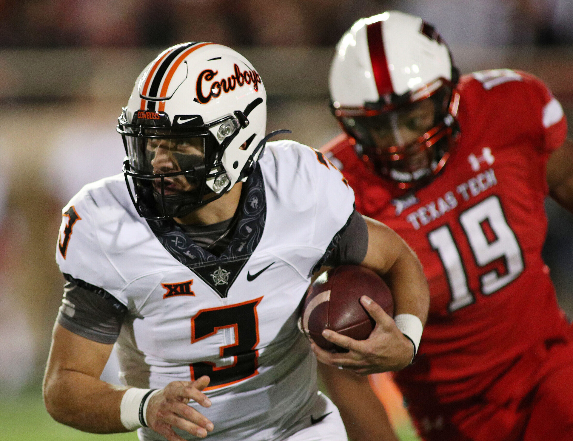 Oklahoma State Cowboys quarterback Spencer Sanders (left) runs the ball against Texas Tech Red Raiders defensive lineman Tyree Wilson (right)