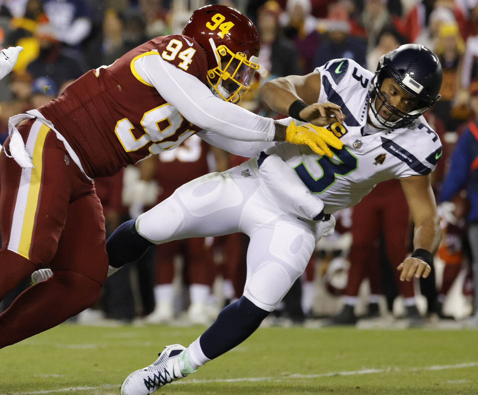 Washington Football Team defensive tackle Daron Payne (left) hits Seattle Seahawks quarterback Russell Wilson (right) after passing the ball