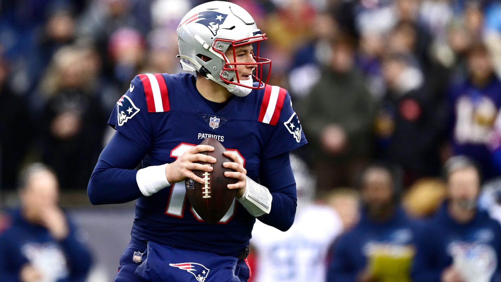 Mac Jones #10 of the New England Patriots looks to make a pass play against the Tennessee Titans in the first quarter at Gillette Stadium on November 28, 2021 in Foxborough, Massachusetts.