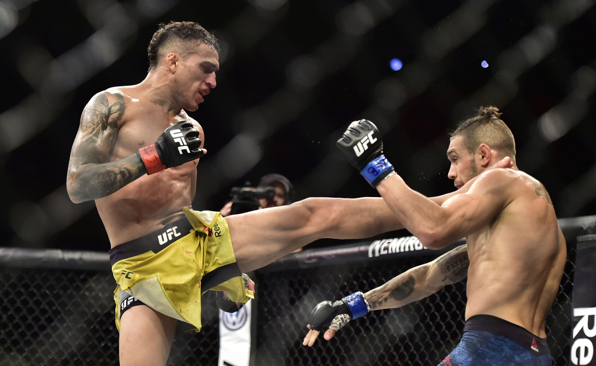 Charles Oliveira (left) strikes opponent Christos Giagos (right) with his leg during UFC Fight Night