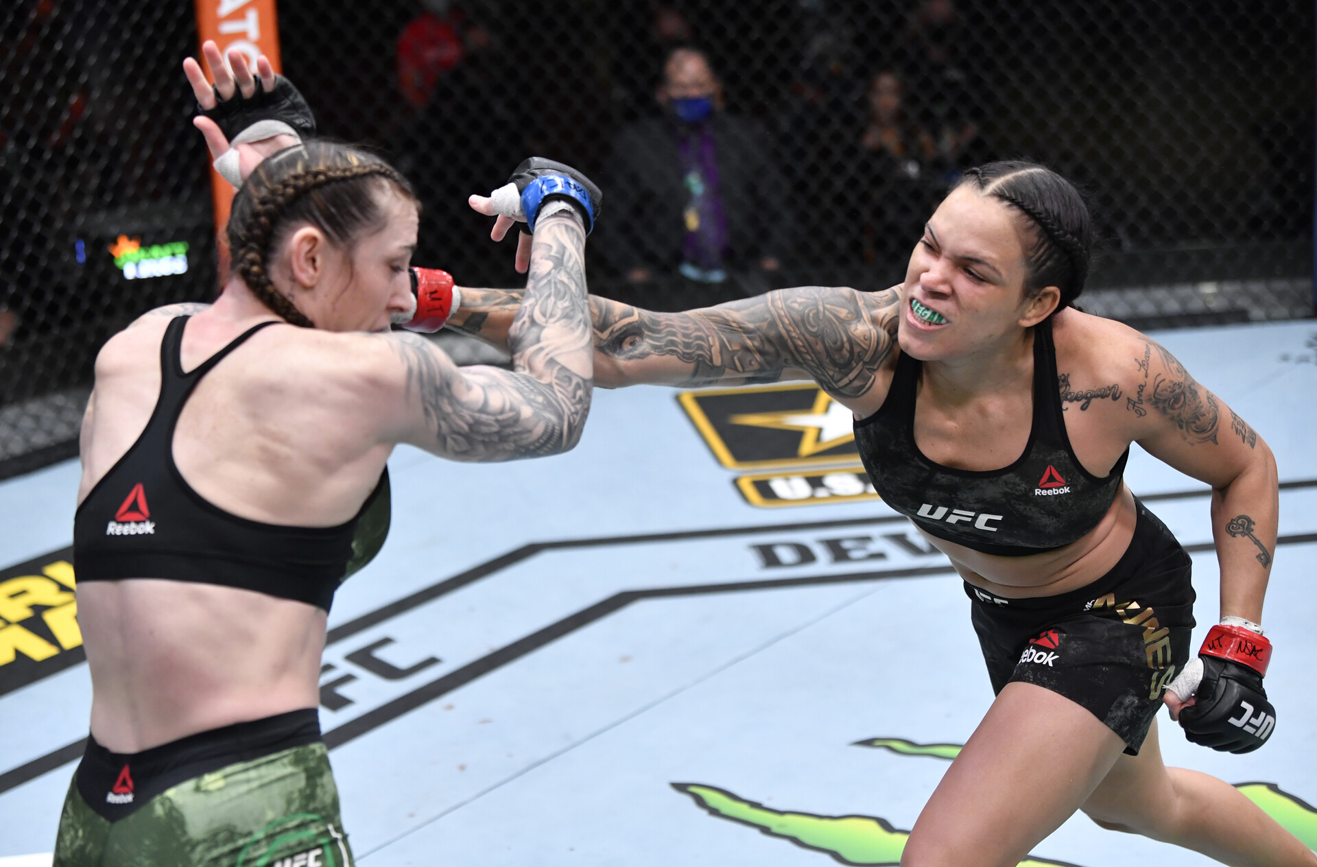 Amanda Nunes (right) lands a punch to the face of Megan Anderson (left) in their UFC featherweight championship fight during the UFC 259