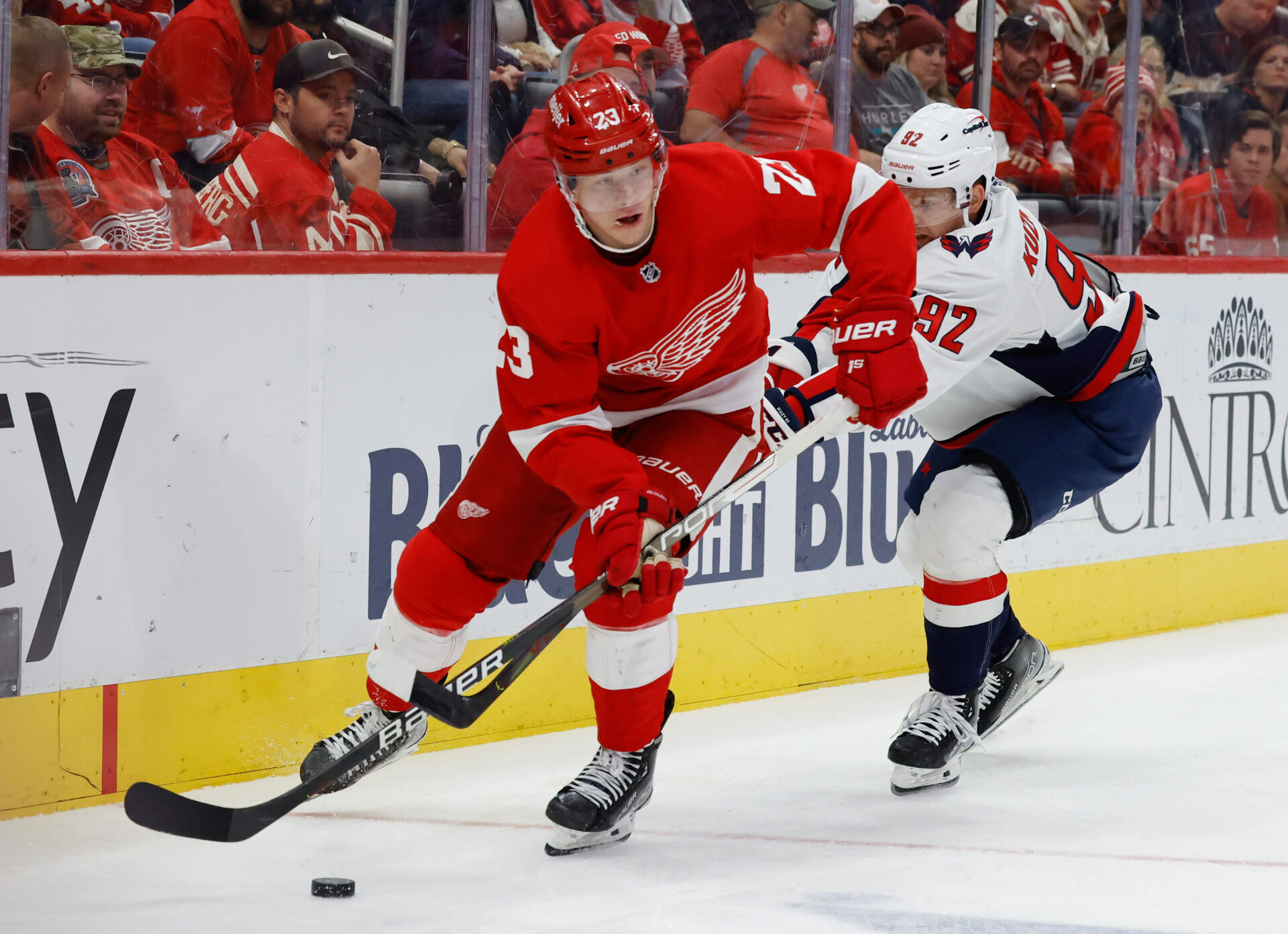Detroit Red Wings right wing Lucas Raymond (left) skates with the puck while Washington Capitals center Evgeny Kuznetsov trails behind